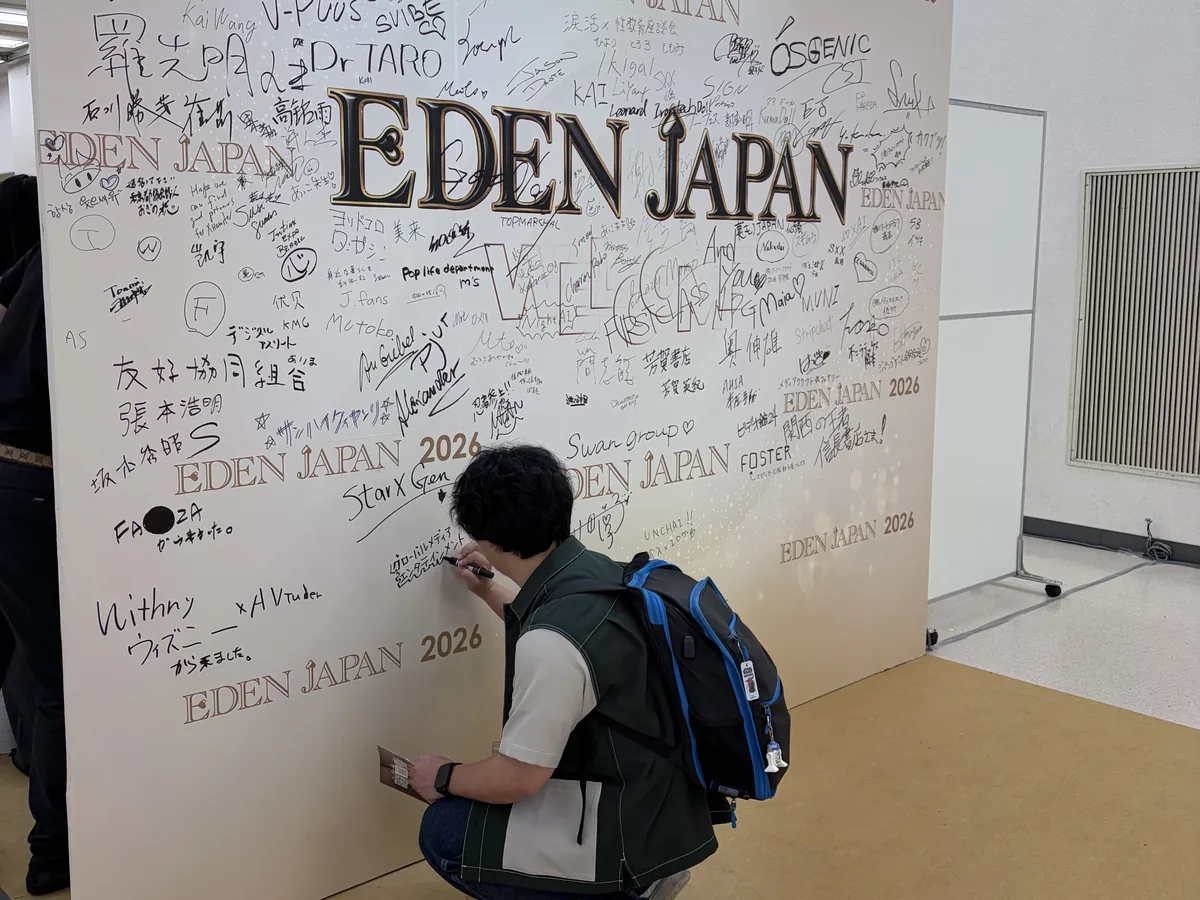 サインボードにメッセージを書き込む来場者
