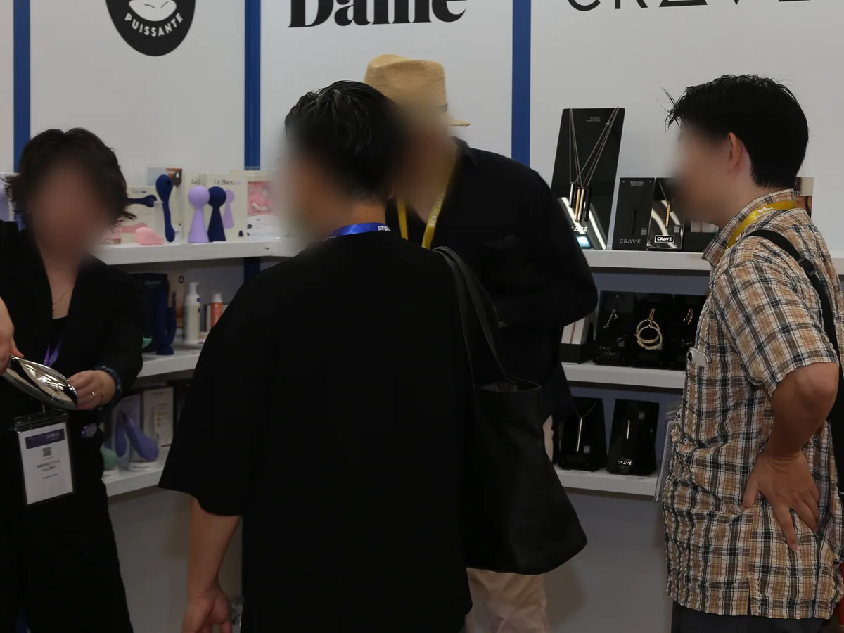 ブースの製品を前に商談する来場者